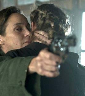 "Westwall - Kapitel VI": Ira (Jeanette Hain) hält Julia (Emma Bading) im Arm und zielt gleichzeitig mit einer Pistole auf die andere Seite des Raums.