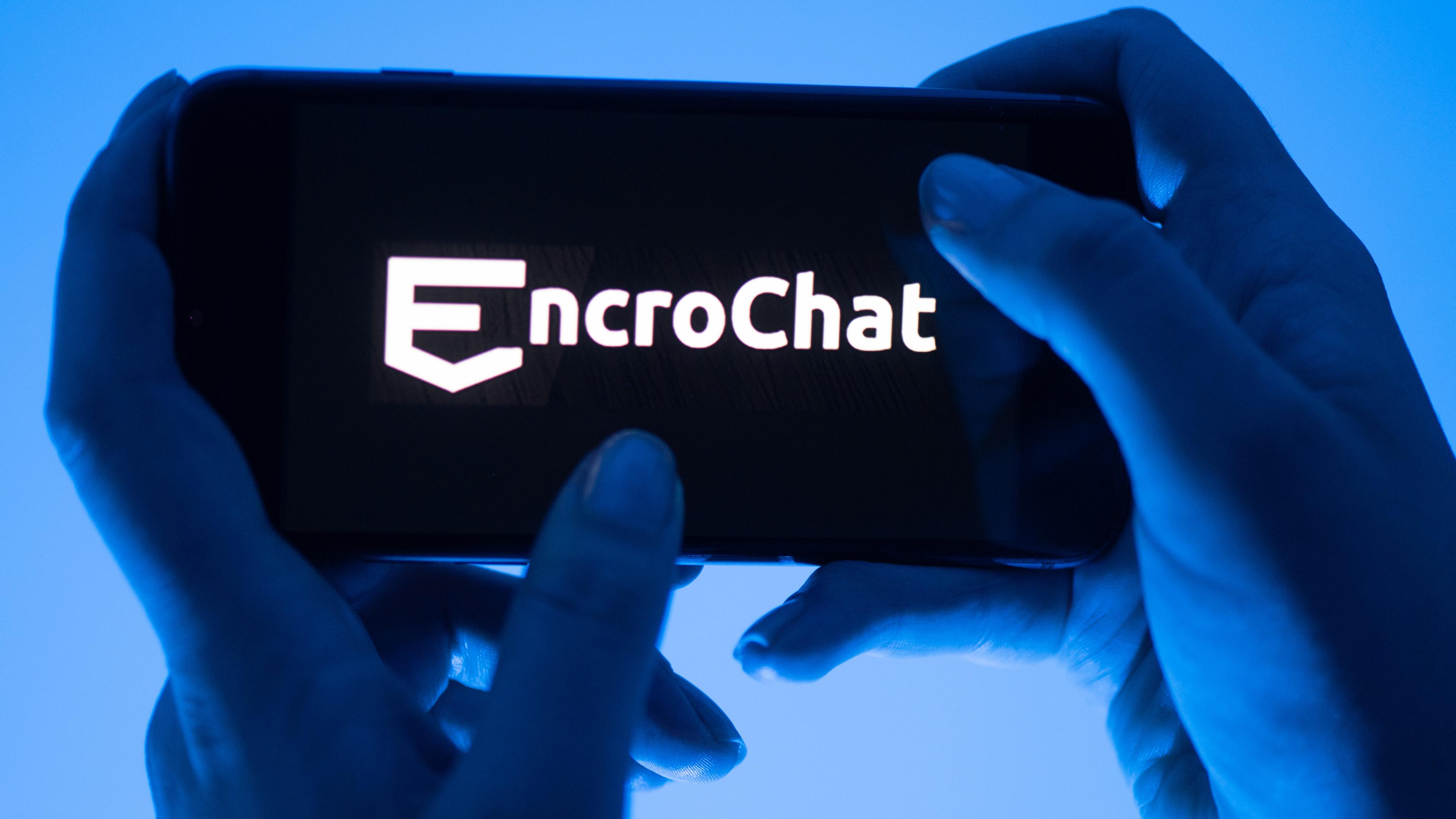 Eine Frau hält ein Smartphone mit dem Logo des Krypto-Messengerdienstes Encrochat