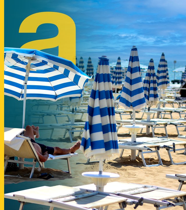 Viele Reihen von Strandliegen mit blau-weißen Schirmen