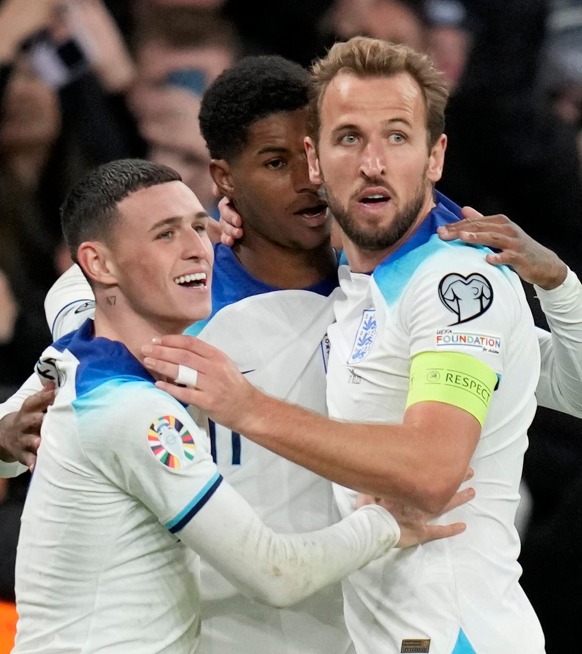 Englische Nationalspieler umarmen sich und jubeln.