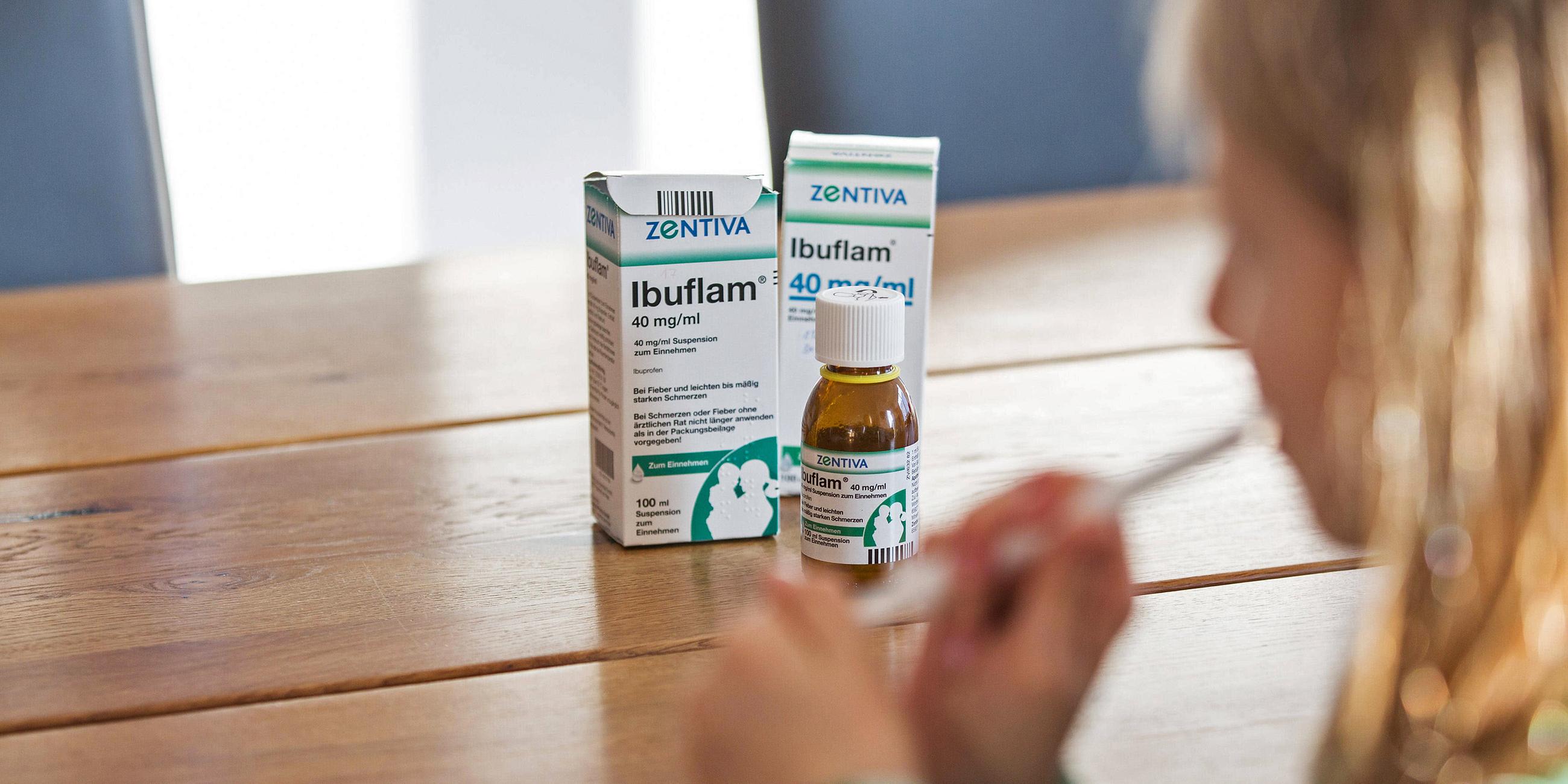 Auf einem Tisch steht eine Flasche Fiebersaft für Kinder