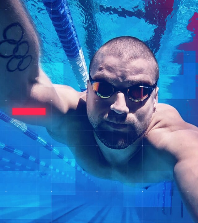 Unterwasseraufnahme des Schwimmers Marius Kusch im Becken während des Trainings. Der ehemalige Olympia-Sportler trägt eine Schwimmbrille und streckt den Arm nach vorn in Richtung Kamera. Auf dem Oberarm ist ein Tattoo mit olympischen Ringen zu sehen. Im Hintergrund verlaufen die Leinenbahnen des Pools, das Bild ist in kräftigen Blau- und Magentatönen gestaltet, zudem ist ein grafisches Raster-Overlay sichtbar.