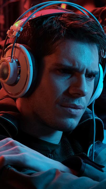 Admiral FOST (Mathieu Kassovitz) und D’Orsi (Omar Sy) blicken auf einen nicht sichtbaren Bildschirm. Vor ihnen sitzt der Chanteraide (François Civil) mit konzentrierter Miene und Kopfhörern.