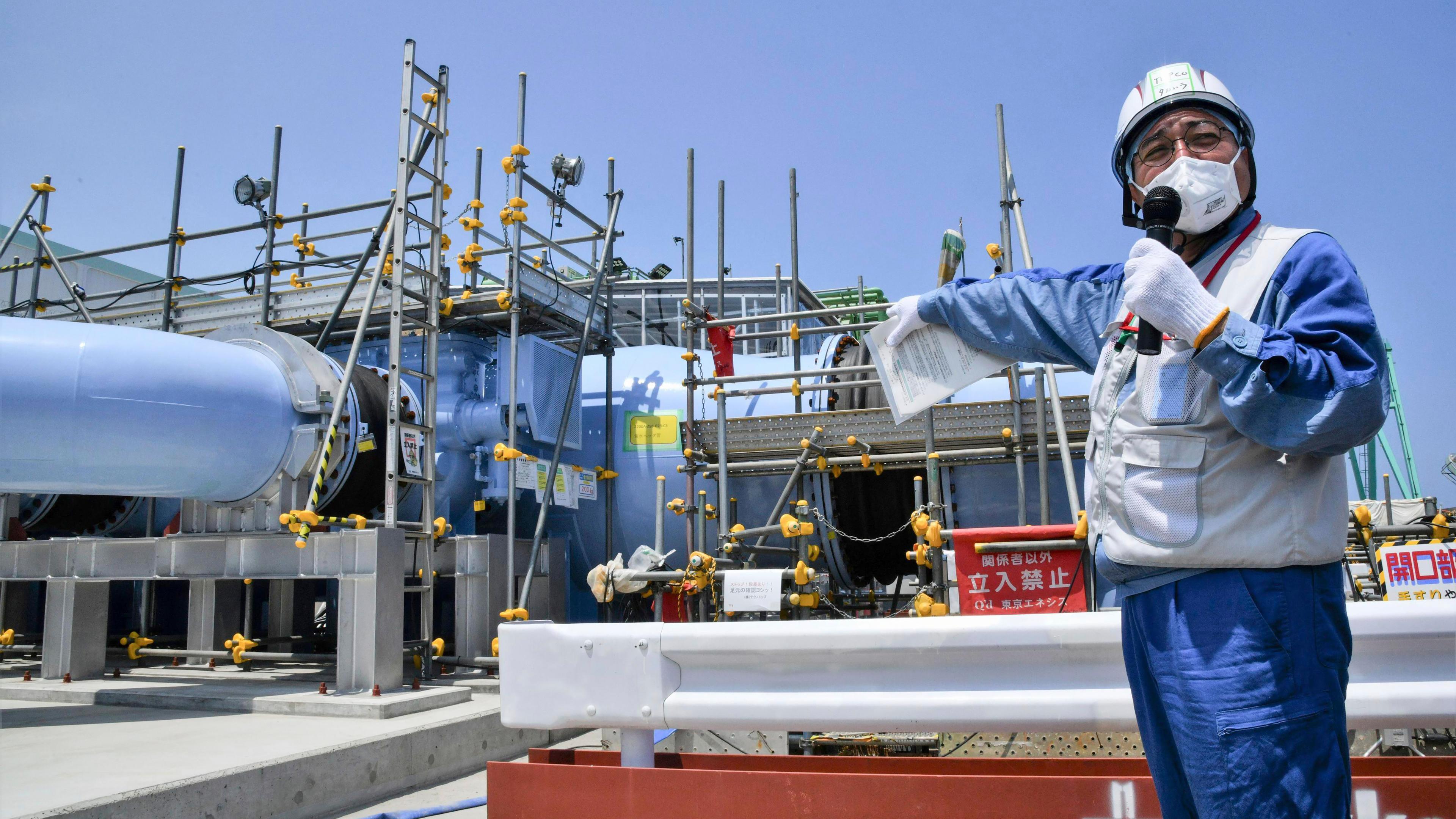 Ein Angestellter erklärt die Anlage, mit der aufbereitetes radioaktives Wasser aus dem Kernkraftwerk Fukushima ins Meer geleitet werden soll, aufgenommen am 26.06.2023