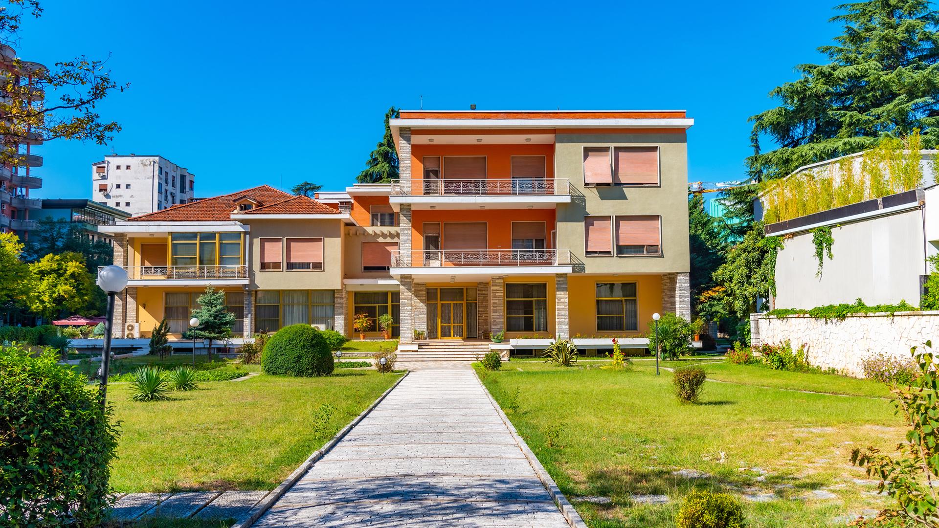 Bild eines zweistöckigen Gebäudes mit einstöckigem Nebenbau.