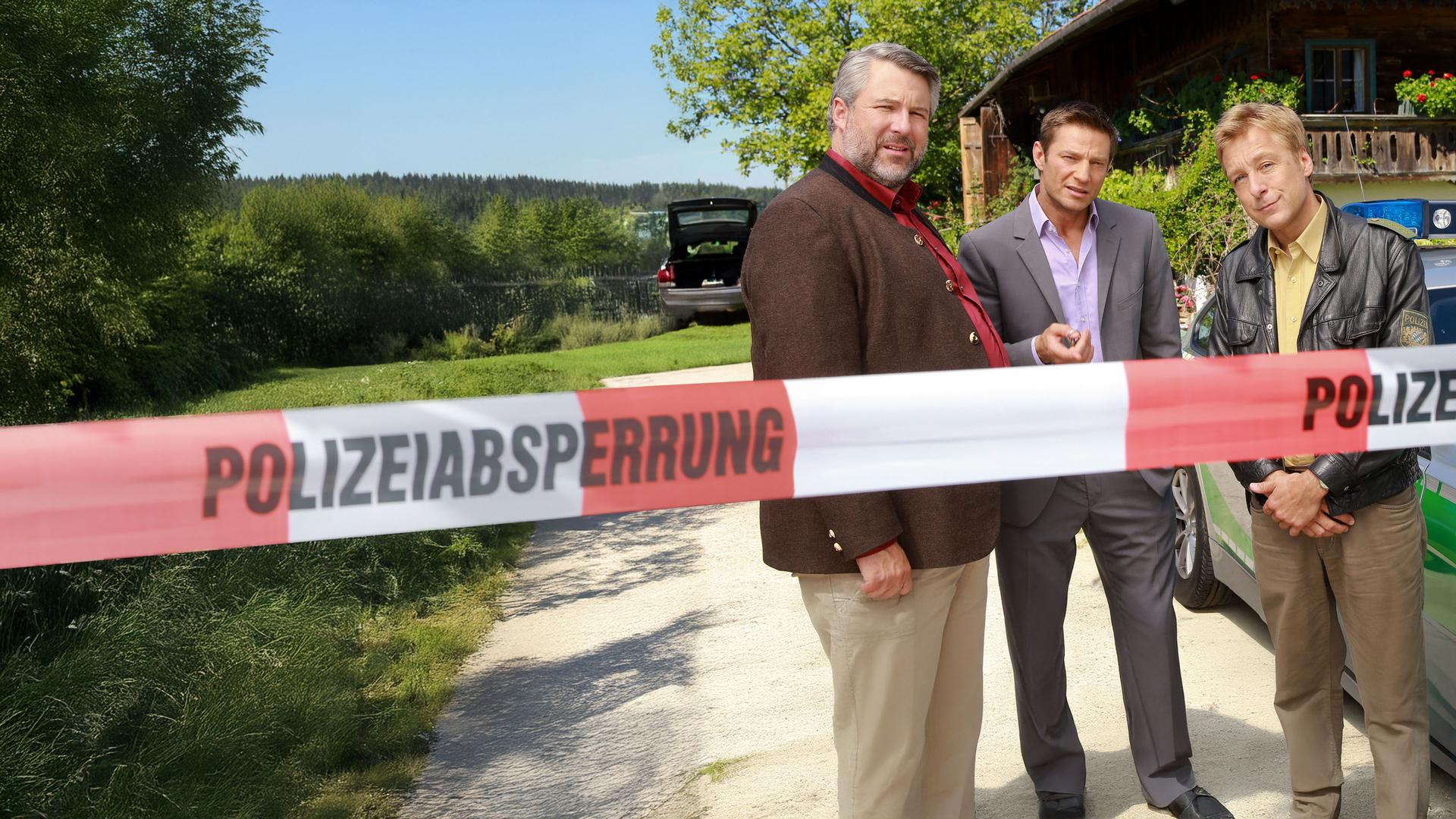 "Die Rosenheim-Cops - Enzian kann tödlich sein": Vor einem Bauernhaus stehen die Kommissare Stadler (Dieter Fischer), Hansen (Igor Jeftic) und Polizist Mohr (Max Müller) neben einem Polizeiwagen.