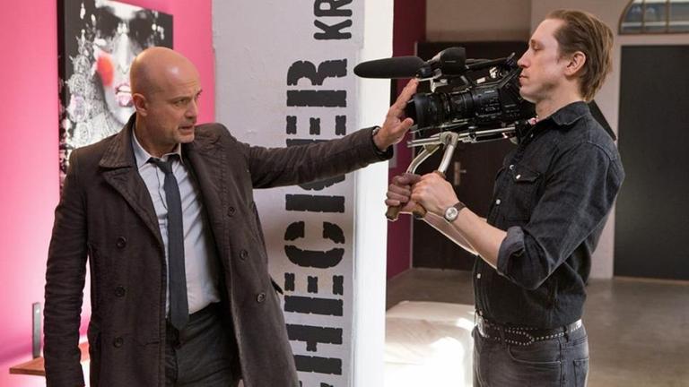 Während Schumann (Christian Berkel, l.) verschiedenen Hinweisen nachgeht, befindet er sich selbst im Fokus der Kameras.