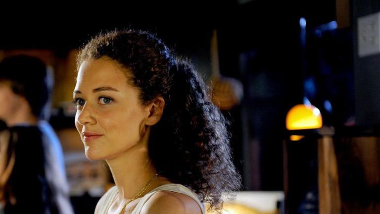 Lucy Westfield (Oona Devi Liebich) genießt die Stimmung in der Bar "Fire and Water" in ihrer Heimatstadt Kingston im Hudson Valley.