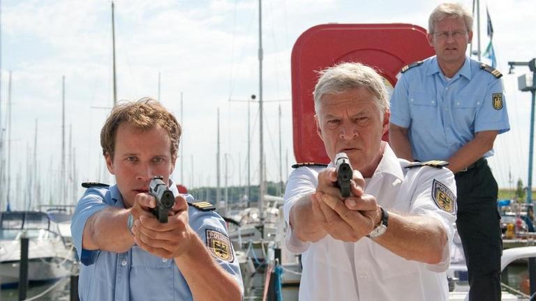 Kapitän Ehlers (Rüdiger Joswig, 2.v.li.), Ben Asmus (Max Florian Hoppe, li.) und weitere Küstenwache-Beamte stürmen das Boot der vermutlichen Täter.
