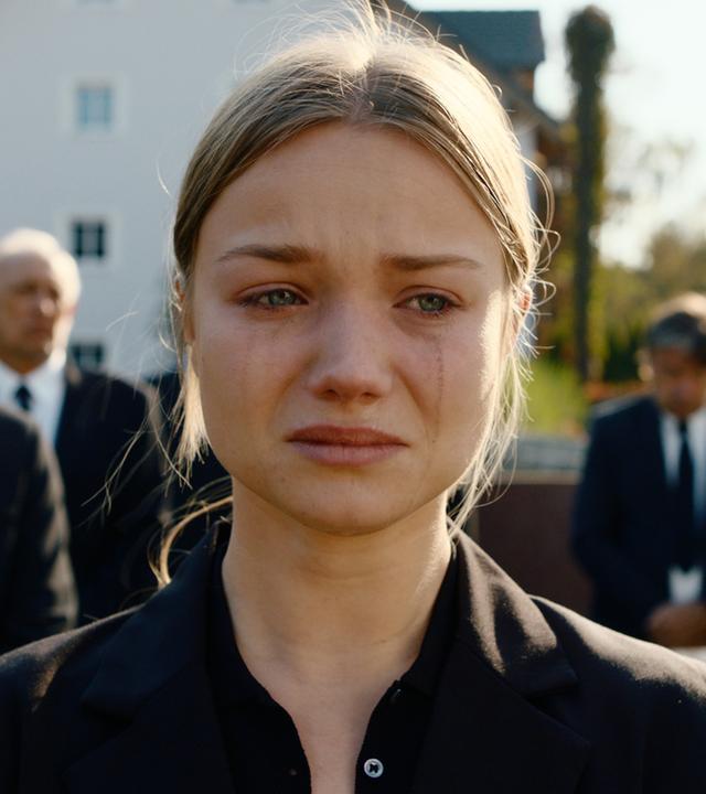 "Gestern waren wir noch Kinder (3)": Nahaufnahme. Vivi Klettmann (Julia Beautx) trägt schwarz und weint, ihr Make-up ist verlaufen. Im Hintergrund sind weitere Trauergäste verschwommen zu sehen.