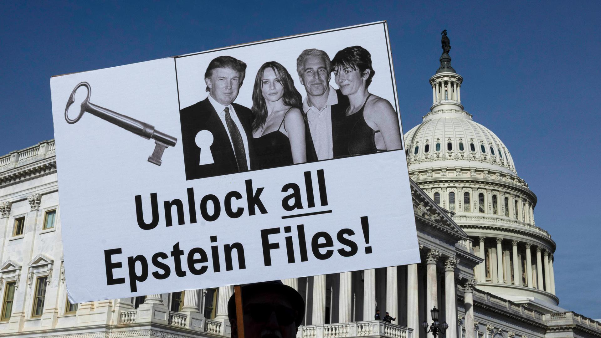 Ein Mann hält ein Plakat hoch, auf dem ein Foto von Trump, Epstein und zwei Frauen zu sehen ist, mit der Forderung, alle Akten offen zu legen.