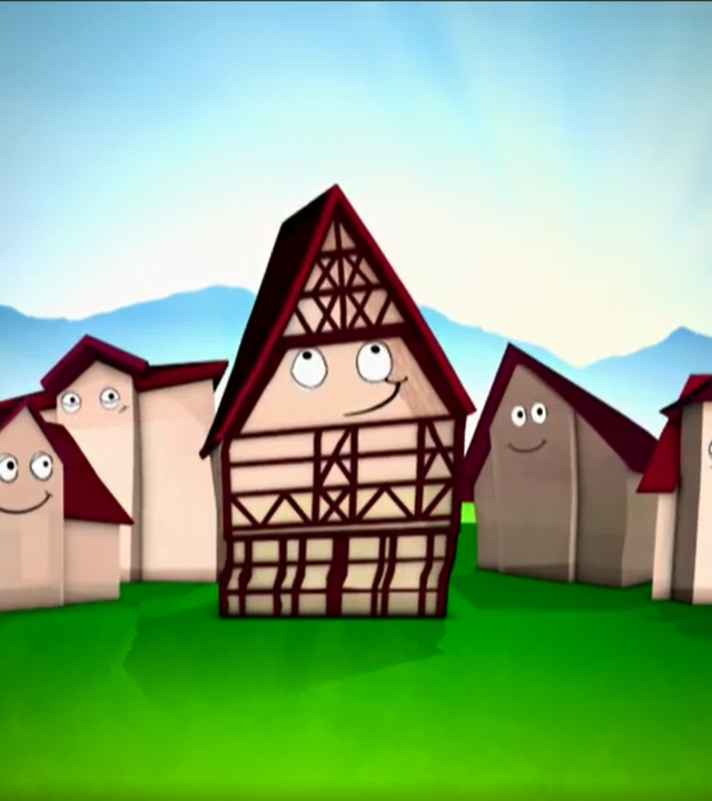 Ein Fachwerkhaus steht zwischen vier Häusern aus Stein.