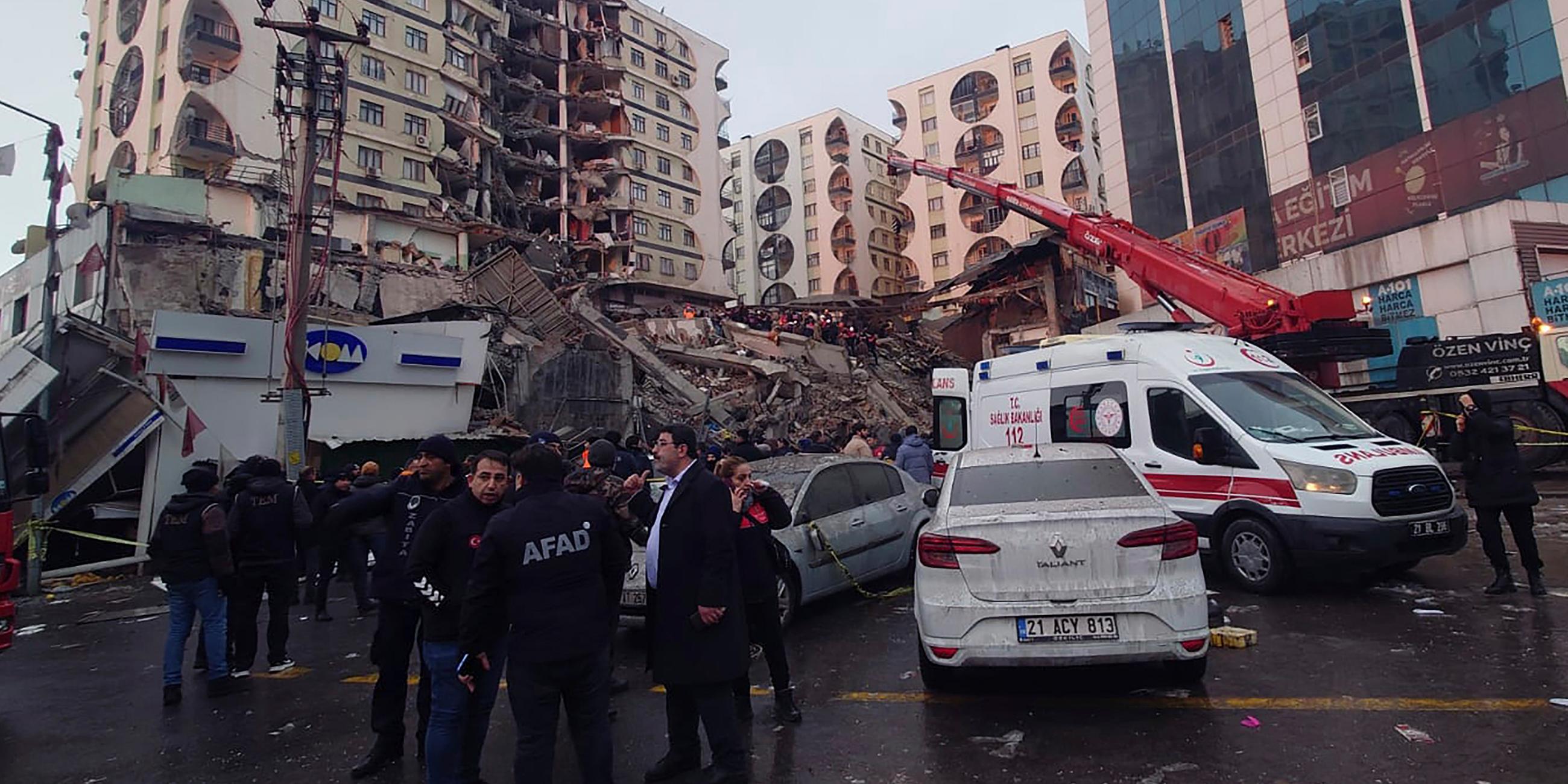 Rettungskräfte und medizinische Teams versuchen in Diyarbakir im Südosten der Türkei verschüttete Bewohner in einem eingestürzten Gebäude nach einem Erdbeben zu erreichen.