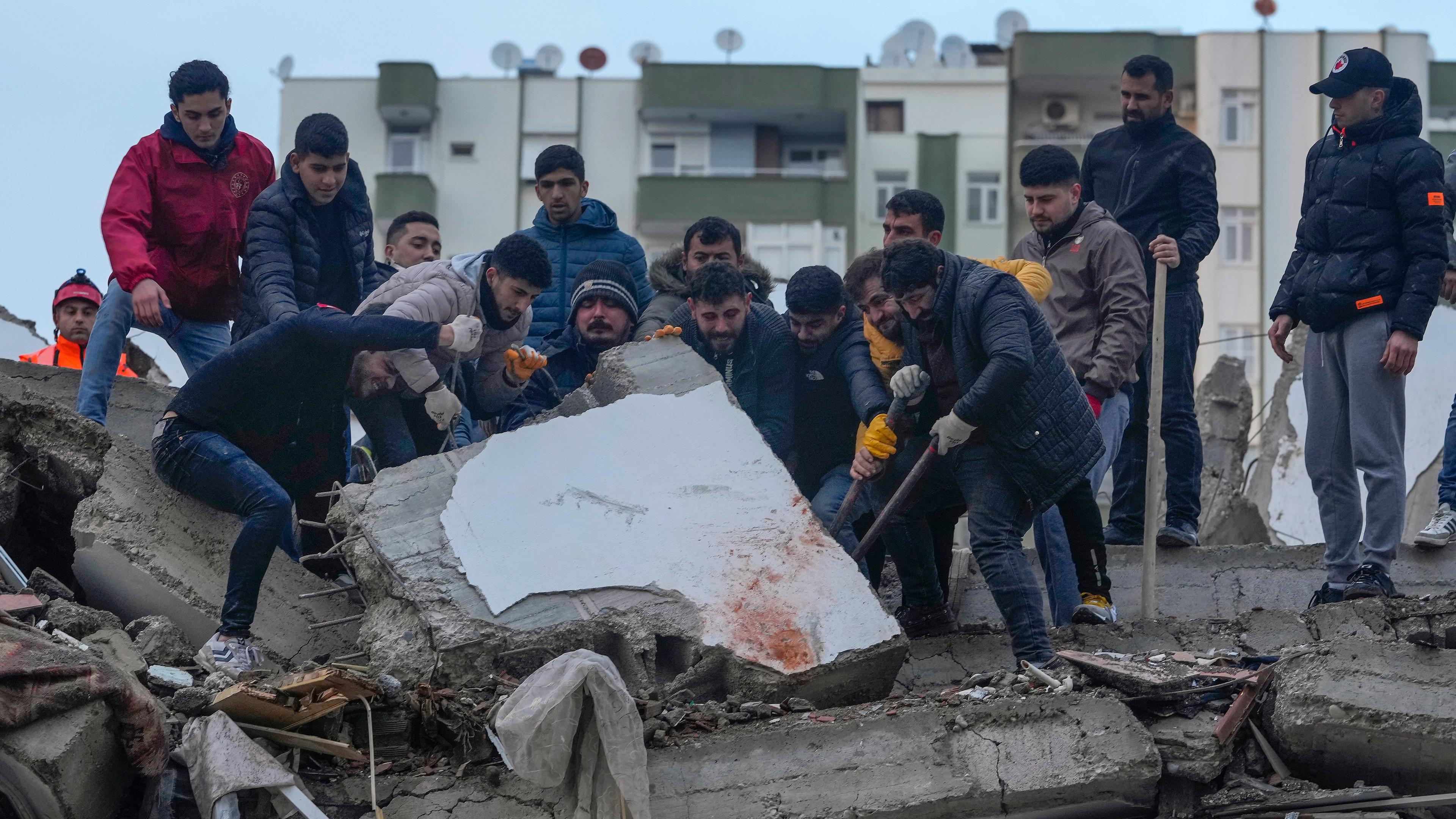 Zivilisten suchen nach Überlebenden in den Trümmern von Gebäuden, aufgenommen am 06.02.2023 in Adana (Türkei)