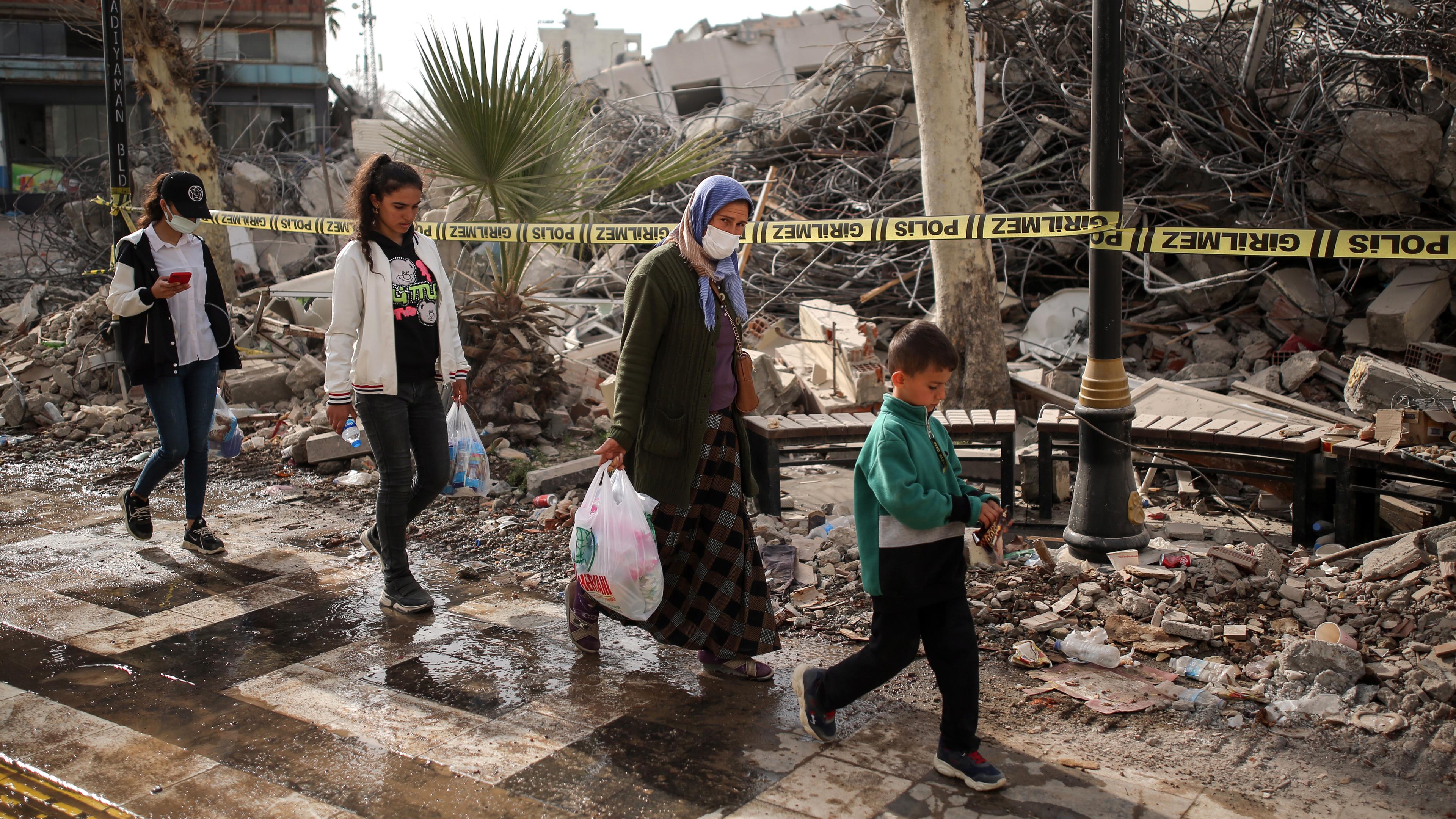 Menschen gehen vor eingestürzten Gebäuden nach einem schweren Erdbeben in Adiyaman(Türkei), aufgenommen am 28.02.2023