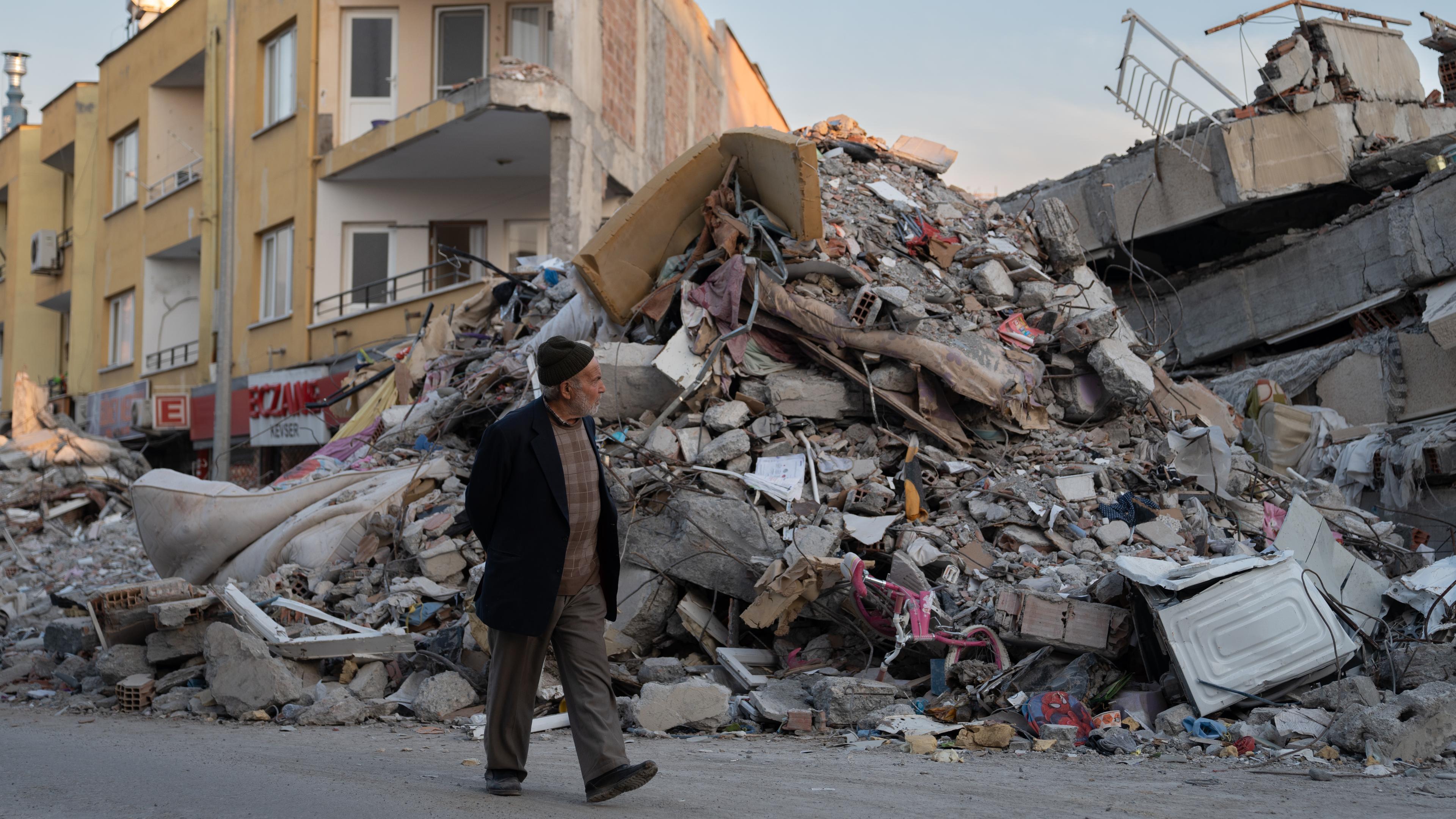 Ein Mann geht durch die Trümmer von Gebäuden, die durch das Erdbeben eingestürzt sind.