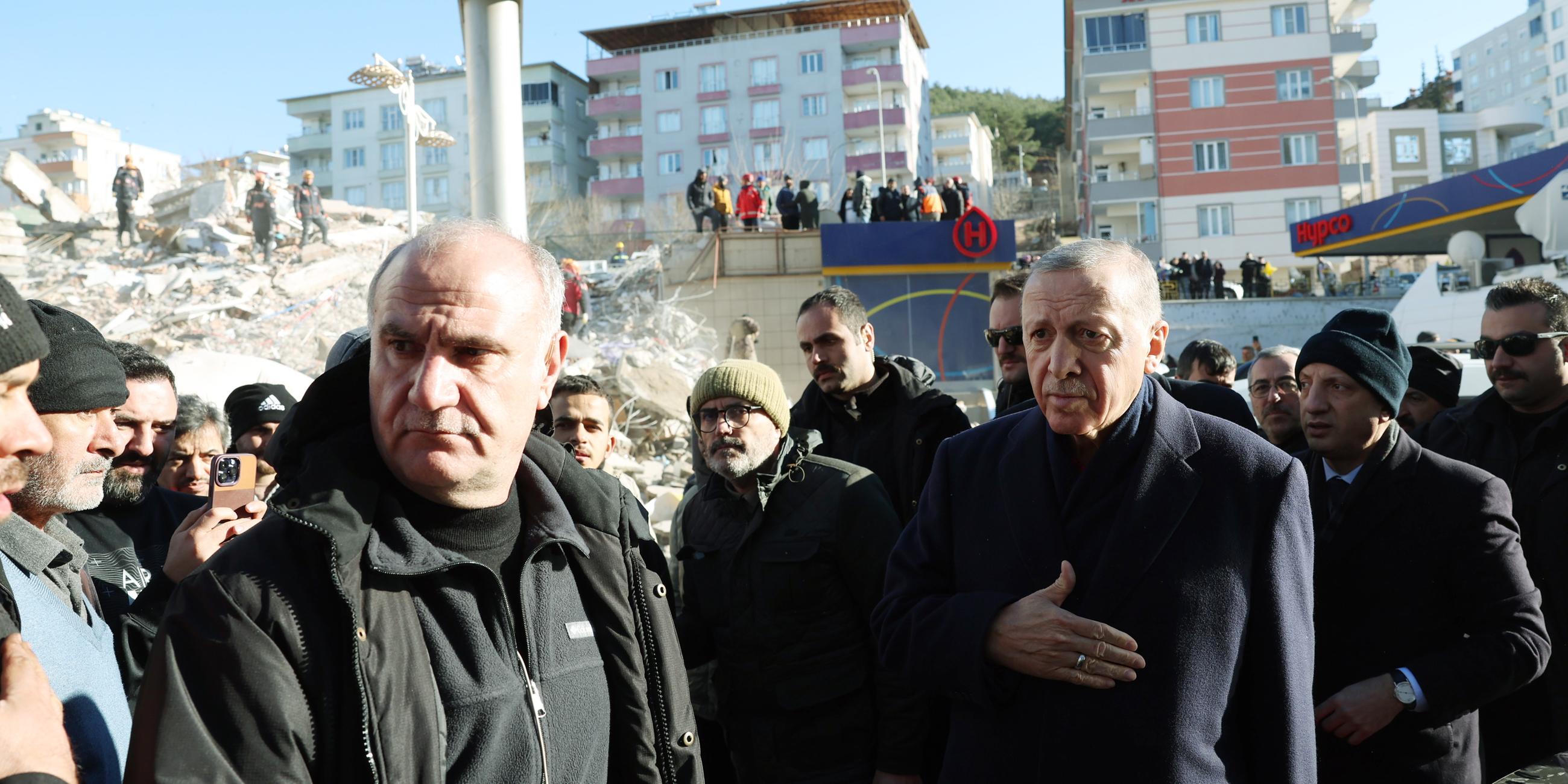 Präsident Erdogan mit vielen Menschen an einem Ort, der vom Erdbeben zerstört wurde.