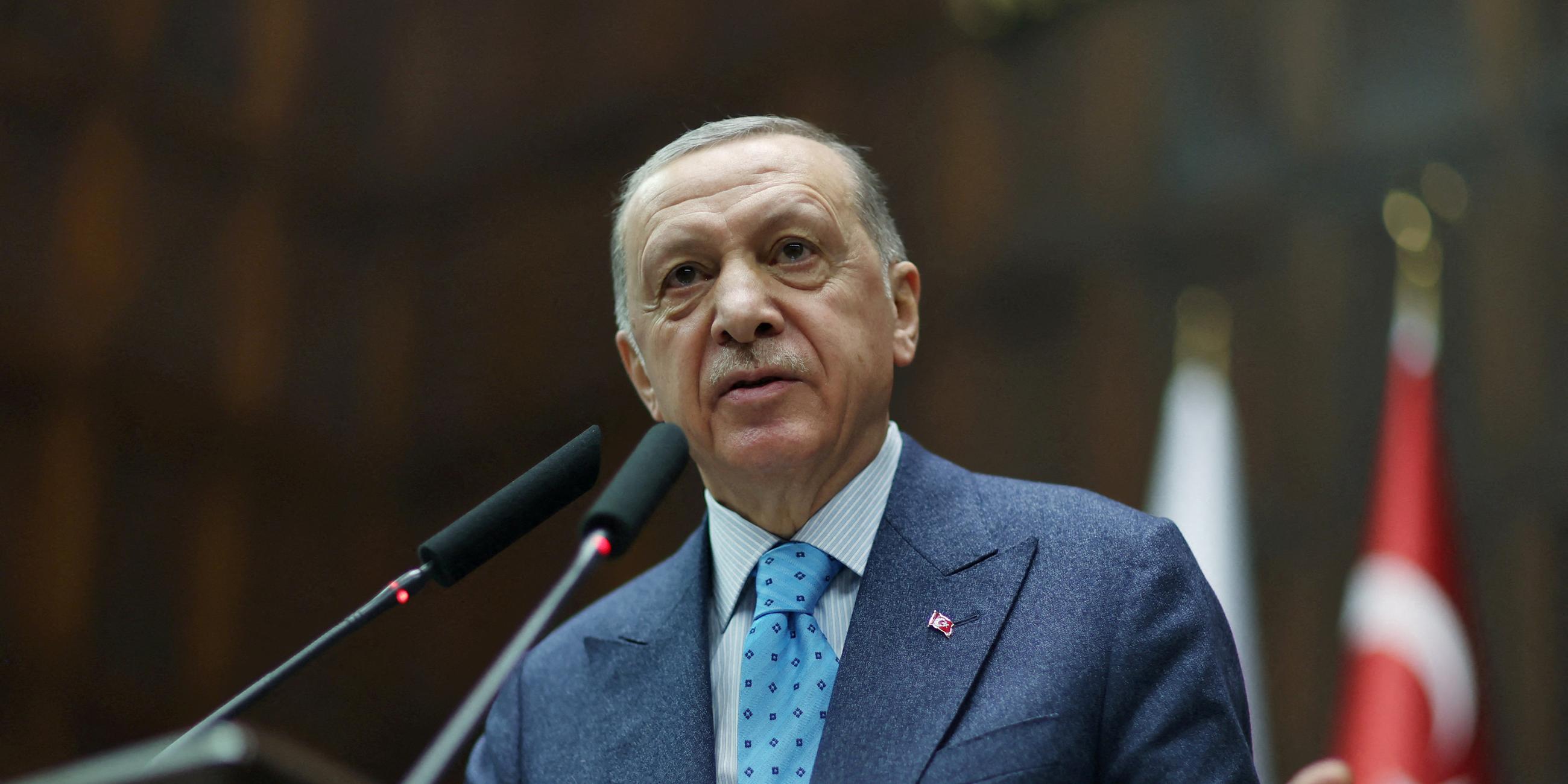 Türkischer Präsident Erdogan steht an einem Mikrofon