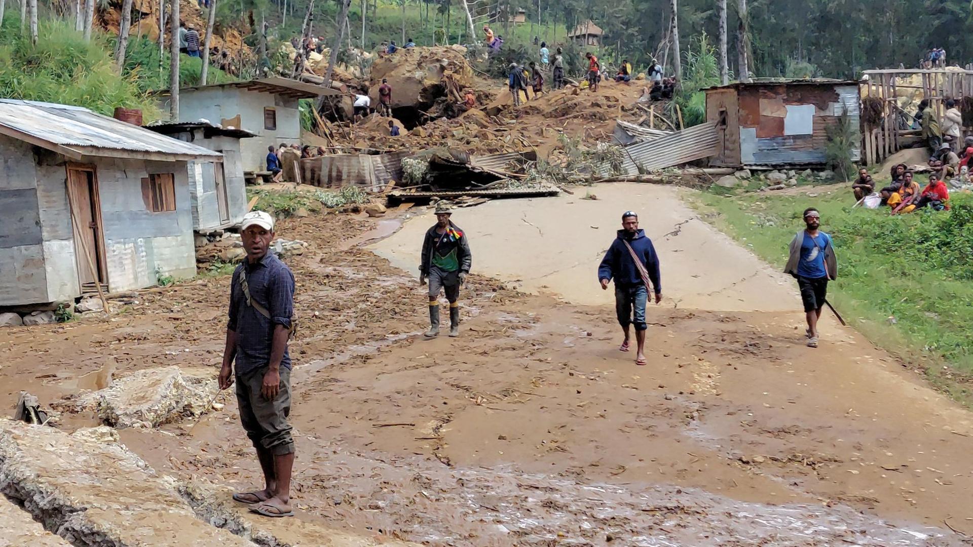Einheimische stehen am 26.05.2024 in der Nähe der Stelle eines Erdrutsches im Dorf Mulitaka in der Region Maip Mulitaka in der Provinz Enga in Papua-Neuguinea.