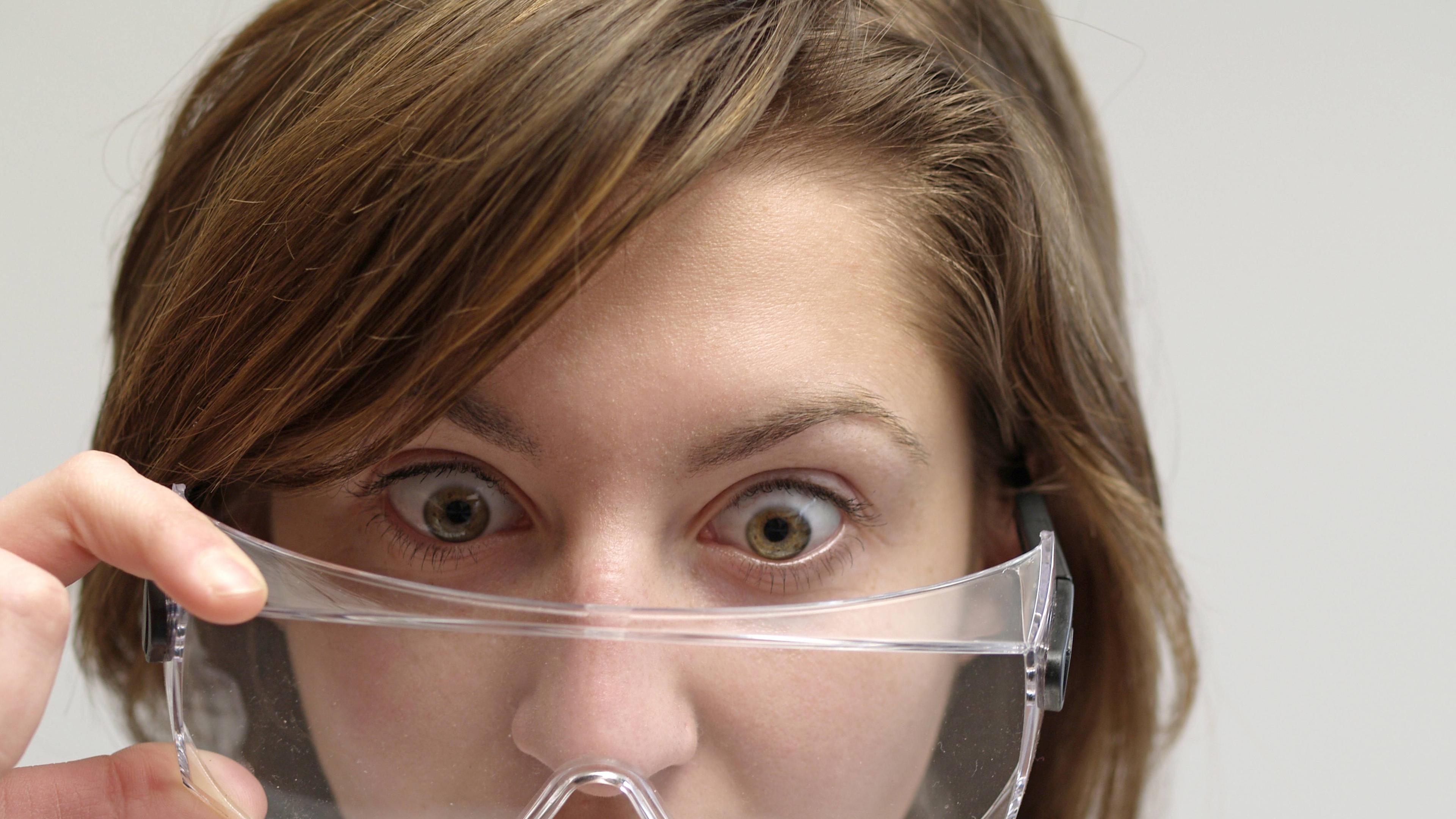 Frau mit Schutzbrille schaut erstaunt
