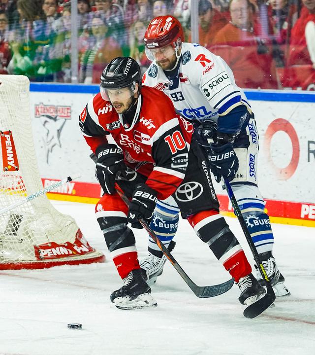 Der Eishockeyspieler der Kölner Haie, Tanner Kero, führt den Puck in der Nähe des Tores der Schwenninger Wild Wings, bedrängt von Kyle Platzer.