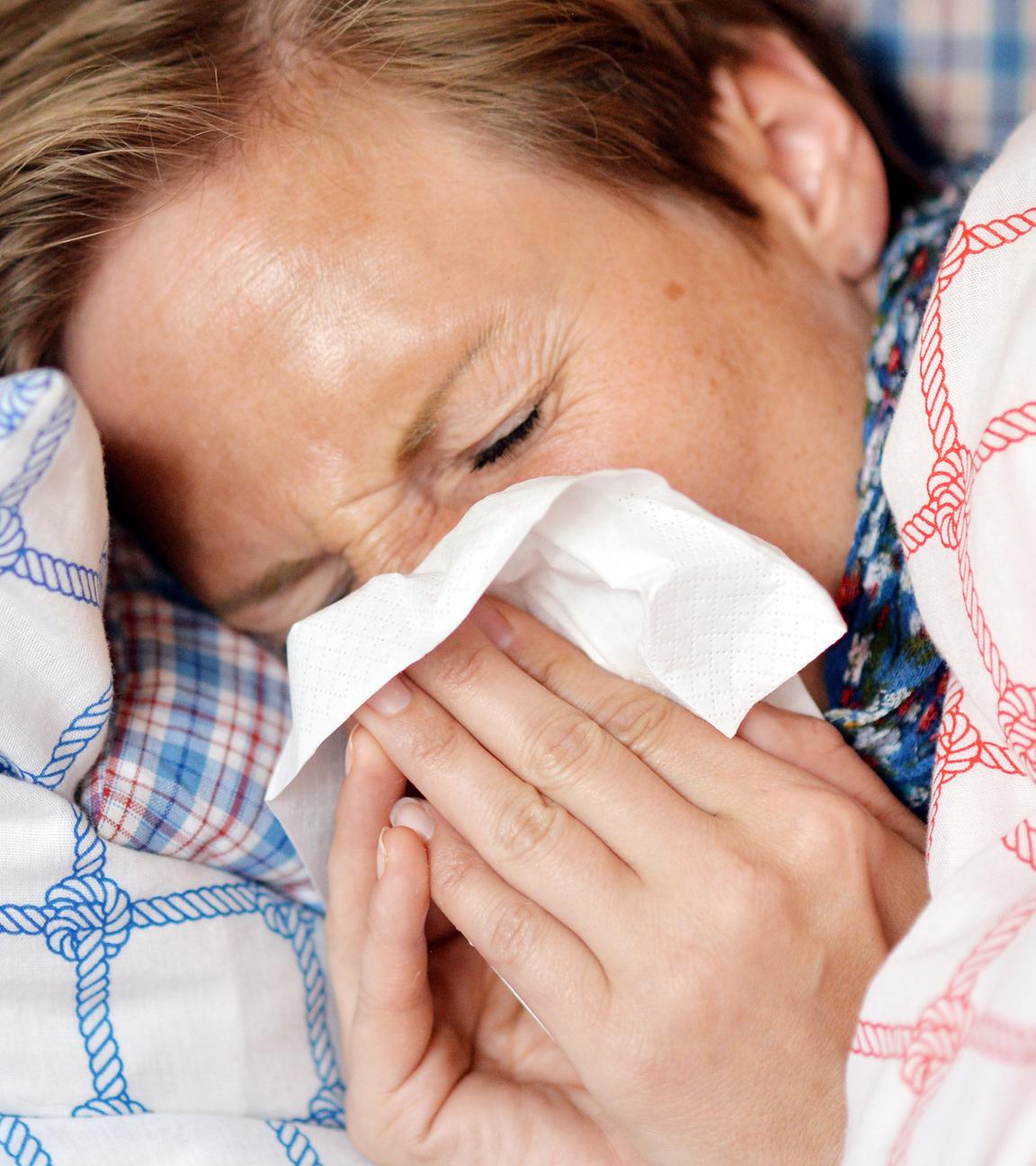 Archiv: eine Frau liegt mit Erkältung im Bett