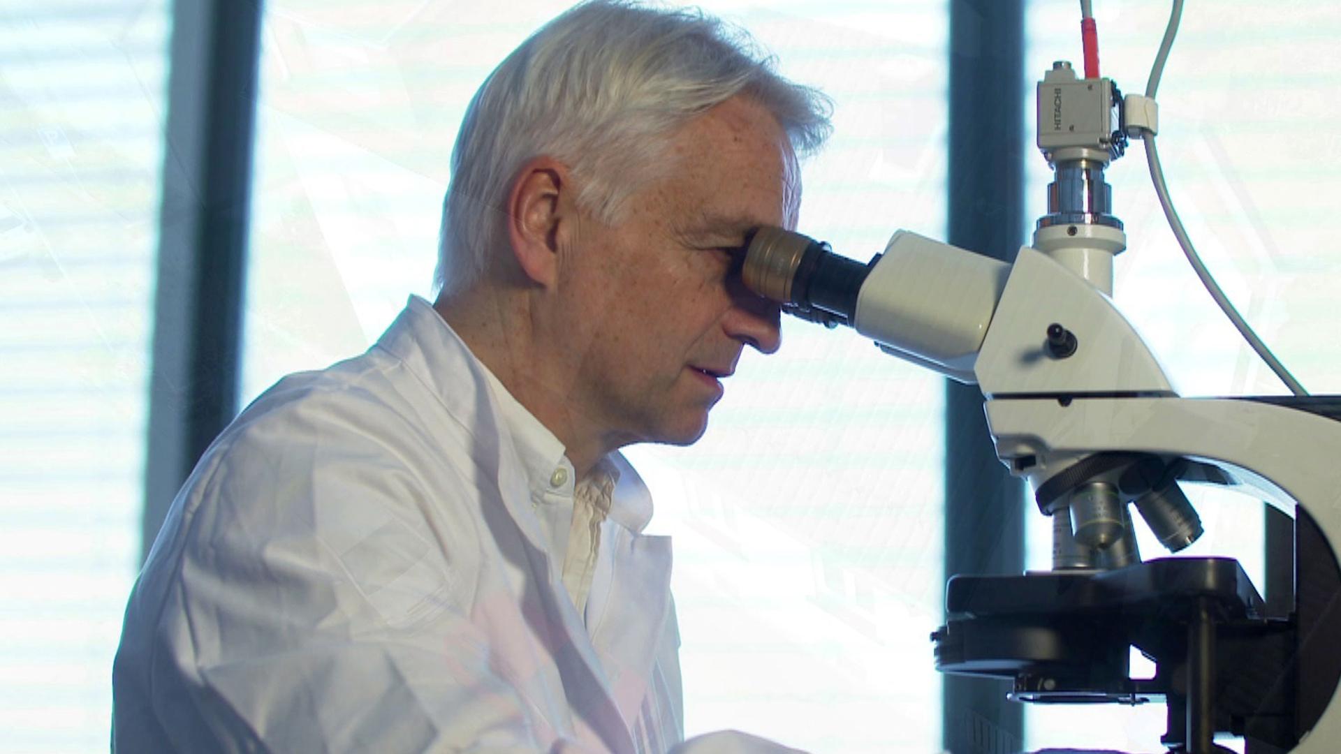 "Ermittler! - Gefährliche Einbrecher": Nahaufnahme von Dr. Harald Schneider beim Untersuchen am Mikroskop.