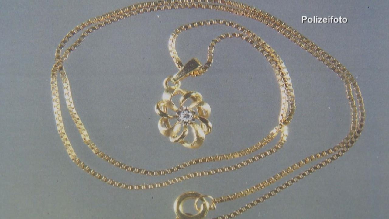 „Ermittler! Heimtückische Pläne”: Polizeifoto des geraubten Schmucks. Eine goldene Kette mit Blumen-Anhänger.