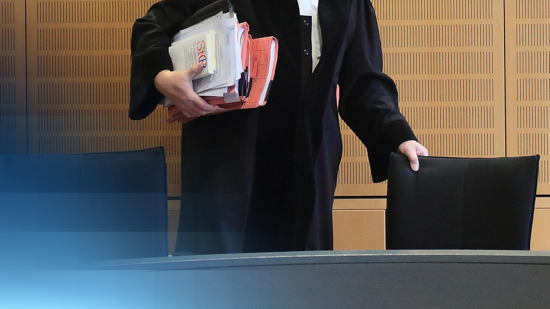 Ein Richter in Robe und Akten in der Hand.