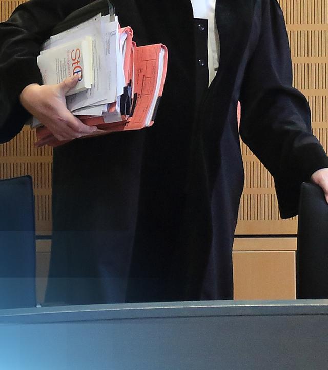 Ein Richter in Robe und Akten in der Hand.