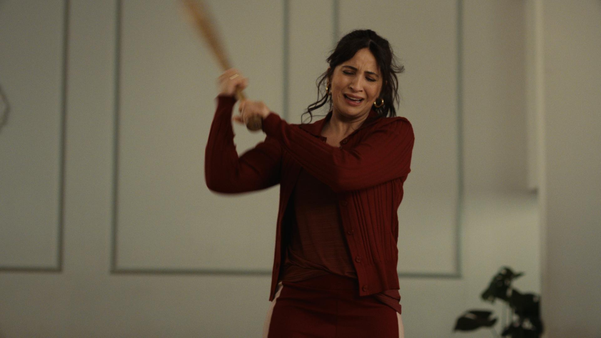 The other gAIrl – error 404 maia not found": Lisa (Chryssanthi Kavazi) steht mit hoch erhobenem Baseballschläger in einem hellen Raum in der Tanzschule.