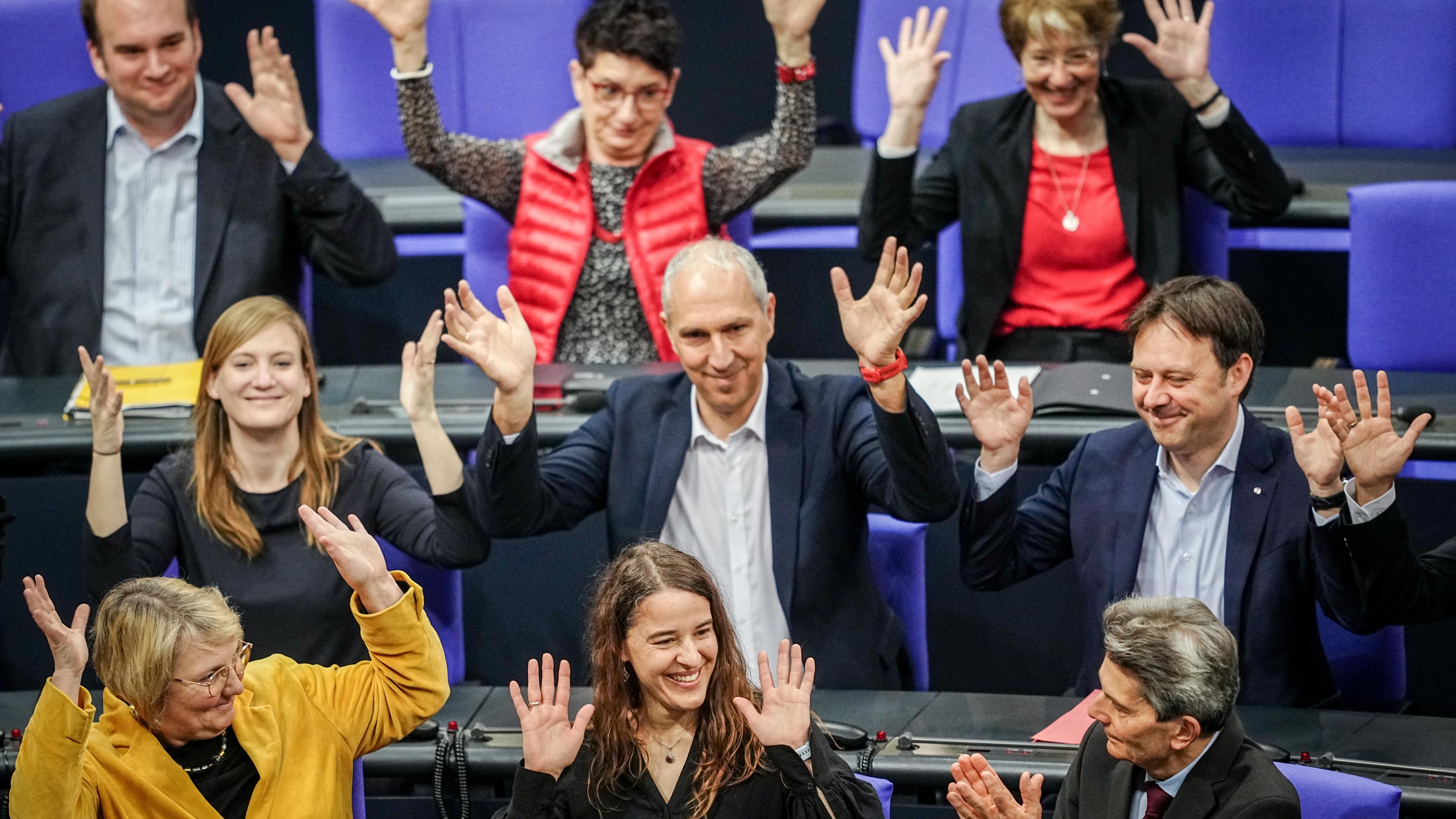 Bundestagsabgeordnete applaudieren in Gebärdensprache für Heike Heubach, die in der Mitte am unteren Bildrand sitzt.