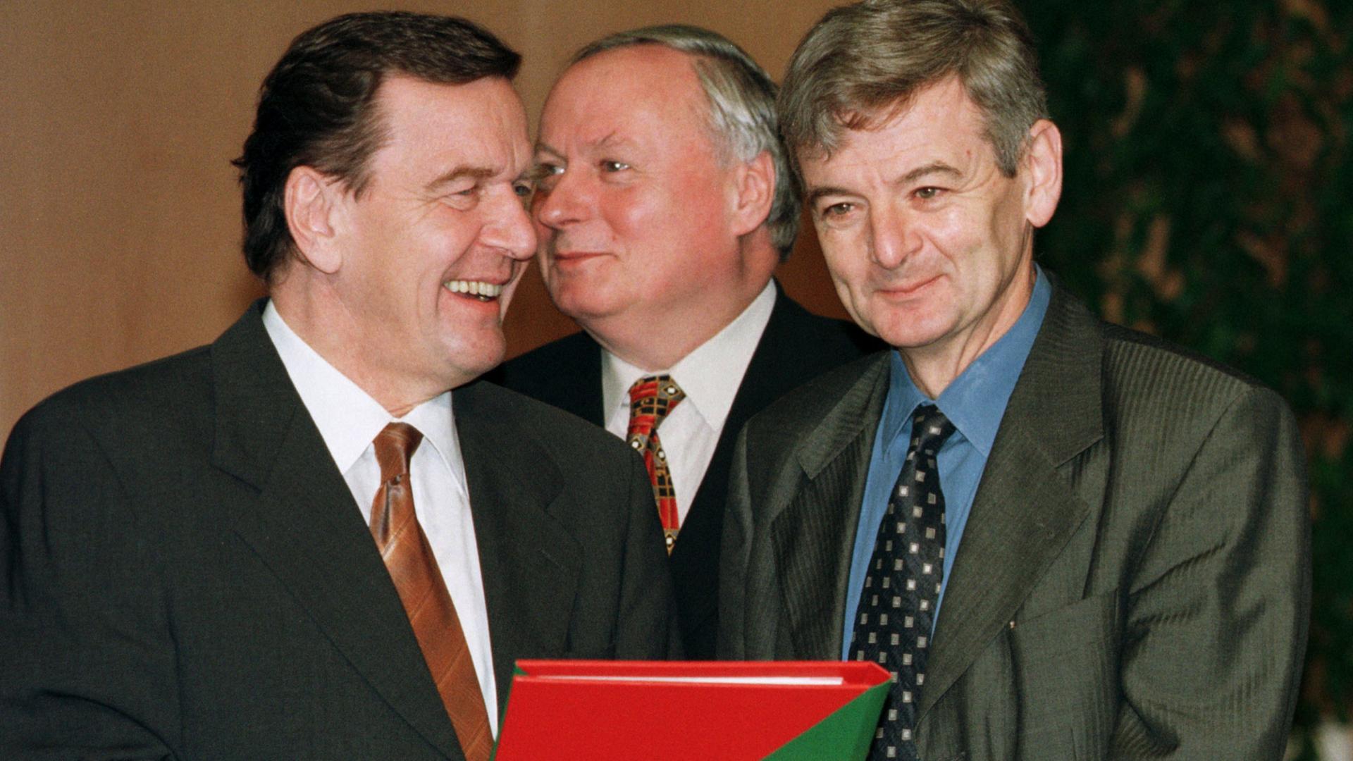 Die erste rot-grüne Bundesregierung: Bundeskanzler Schröder, Finanzminister Lafontaine, Aussenminister Fischer mit dem Koalitionsvertrag