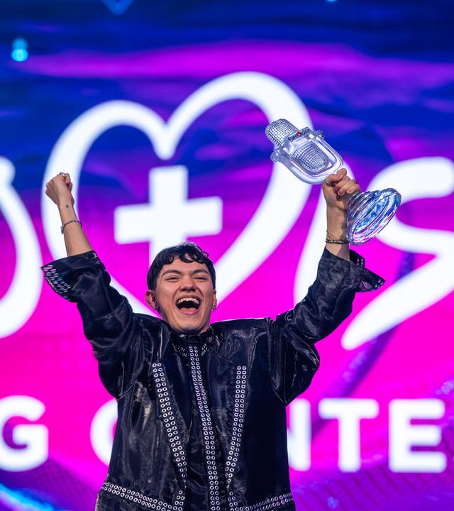 JJ aus Österreich, Gewinner des Eurovision Song Contest, hält während des großen Finales des 69. Eurovision Song Contest (ESC 2025) in der St. Jakobshalle auf der Bühne die Trophäe in der Hand und jubelt.