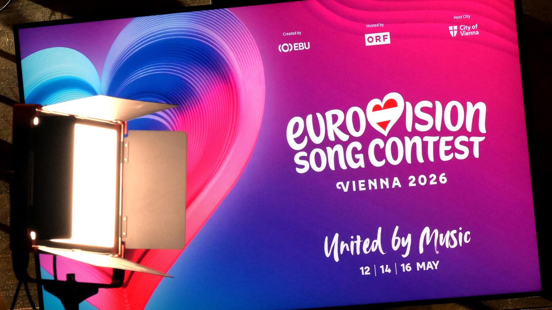 Plakat mit Werbung für den Eurovision Song Contest 2026 in Wien mit Herz in pink-lila Farben.