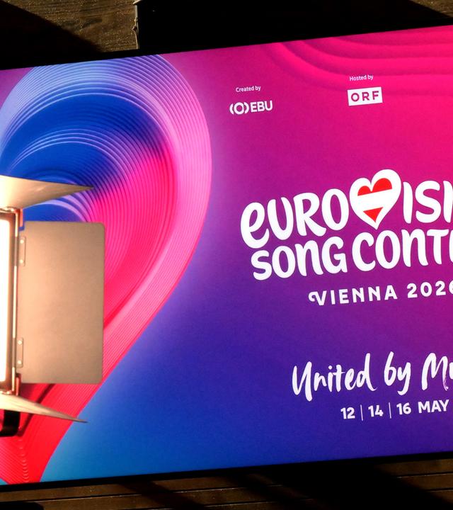 Plakat mit Werbung für den Eurovision Song Contest 2026 in Wien mit Herz in pink-lila Farben.