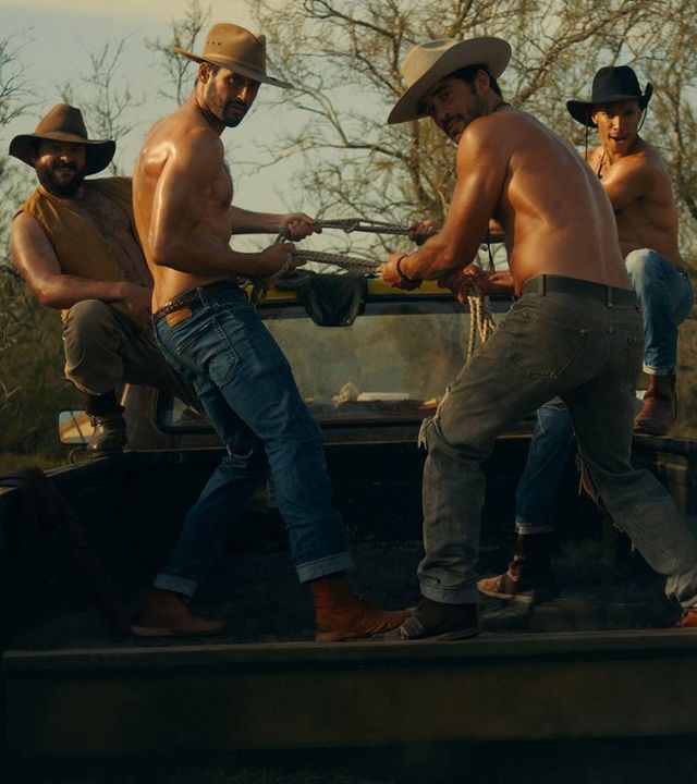 "Escort Boys - Honig ist die Zukunft": Ludo (Thibaut Evrard), Ben (Guillaume Labbé), Mathias (Simon Ehrlacher) und Zak (Corentin Fila) posieren auf der Ladefläche eines Pick-ups. Ludo und Zak hocken außen, Ben und Mathias stehen in der Mitte und halten gemeinsam ein Seil, an dem sie ziehen. Alle tragen Cowboyhüte - nur Ludo trägt zusätzlich eine offene gelbe Weste, die anderen sind oberkörperfrei.