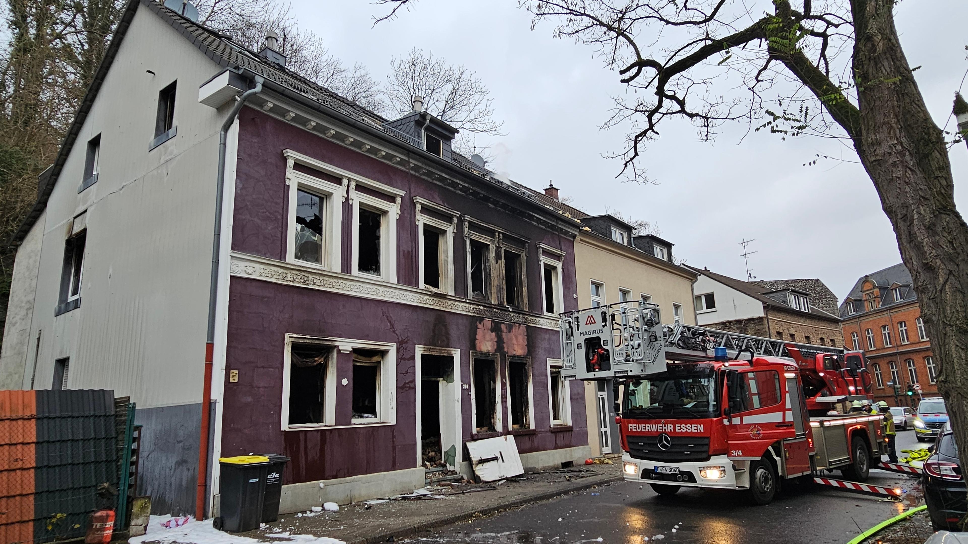 Ein Feuerwehrauto steht nach der Explosion in einem Mehrfamilienhaus vor dem zerstörten Gebäude