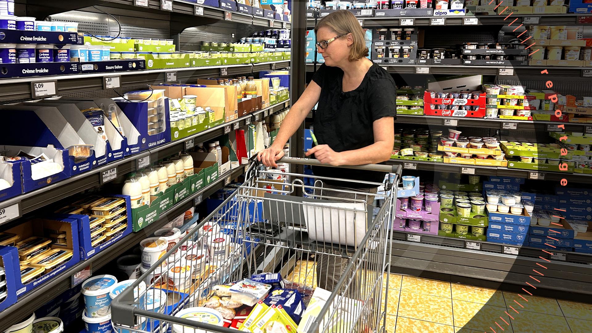 Friederike Pflaum steht mit einem Einkaufswagen vor dem Kühlregal im Supermarkt.