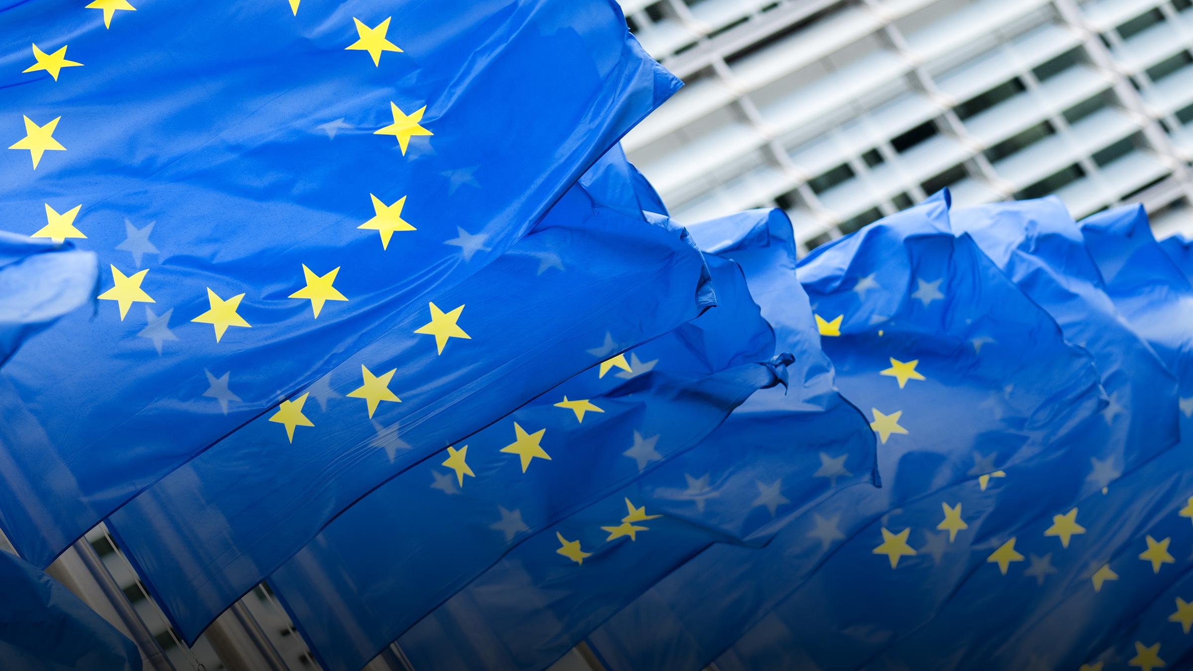 EU-Fahnen wehen vor einem Gebäude der EU in Brüssel.