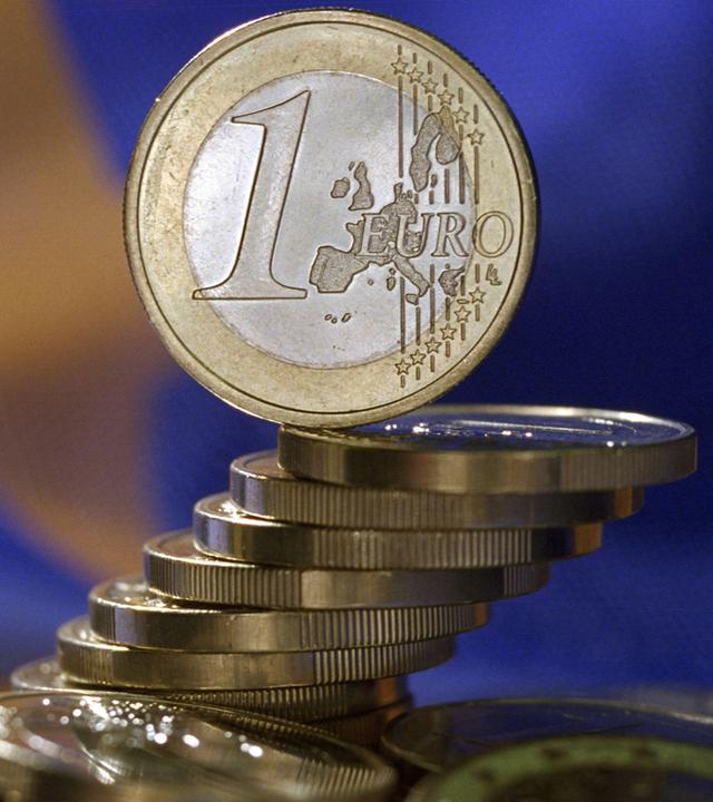 Euro-Münzen vor EU-Flagge