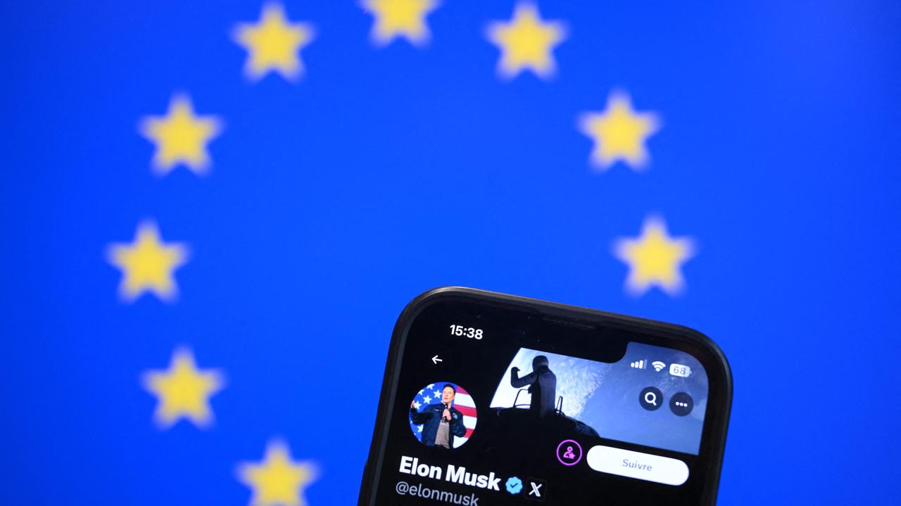 A smartphone shows Musks X-Account in front of an EU flag.