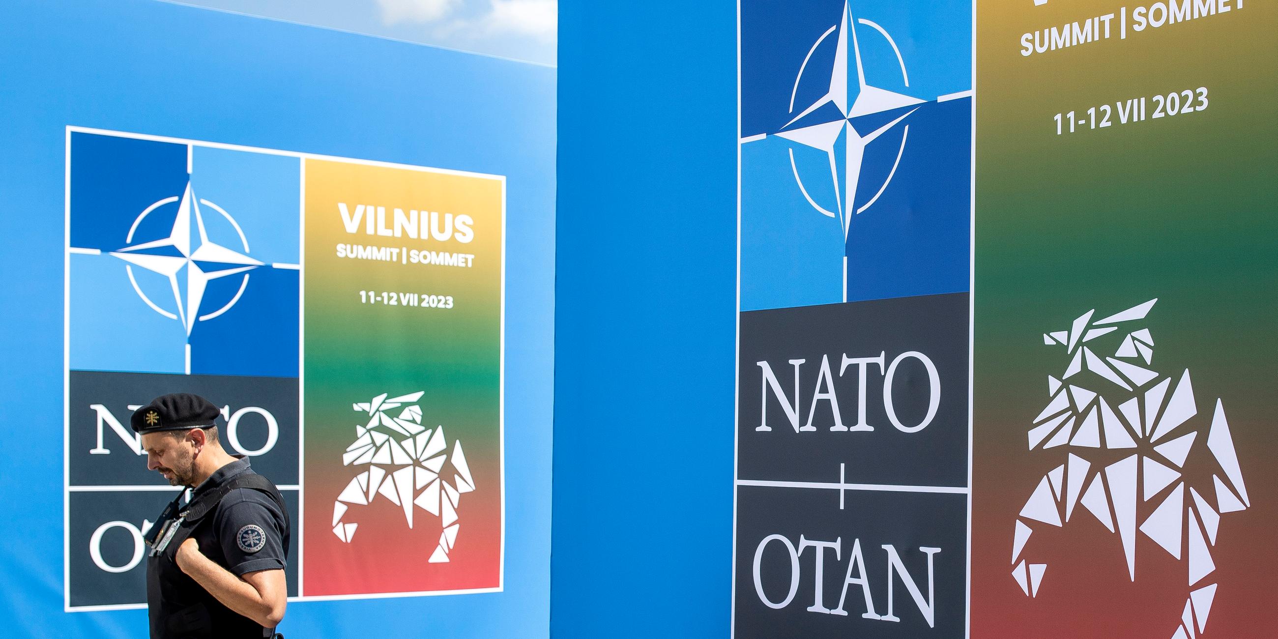 Ein Security-Mann läuft vor dem Banner des Nato-Gipfels in Vilnius.