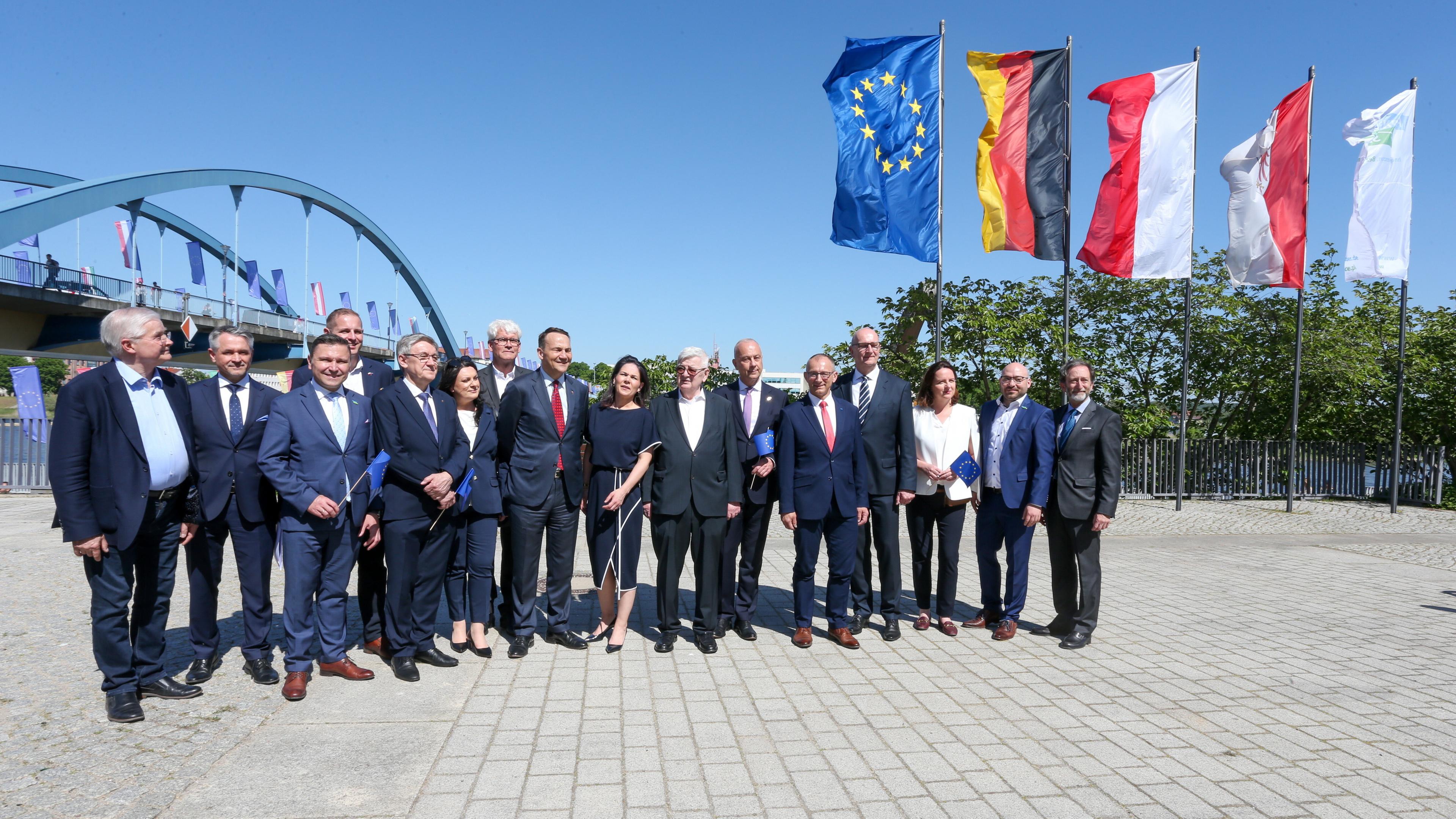 Deutsche und polnische Politiker posieren für ein Foto vor Flaggen Deutschlands, Polens und der EU