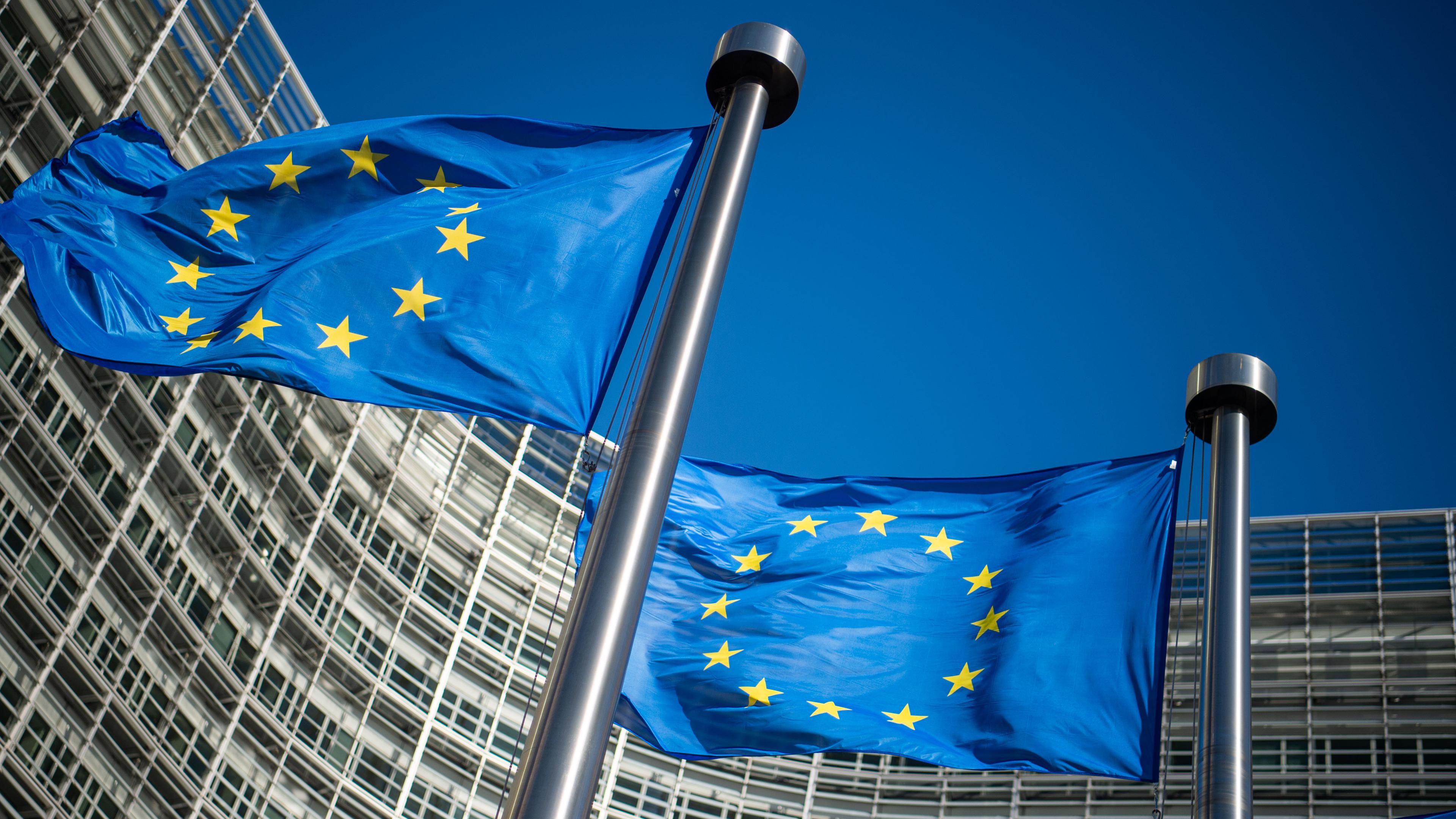 laggen der Europäischen Union wehen im Wind vor dem Berlaymont-Gebäude, dem Sitz der Europäischen Kommission.