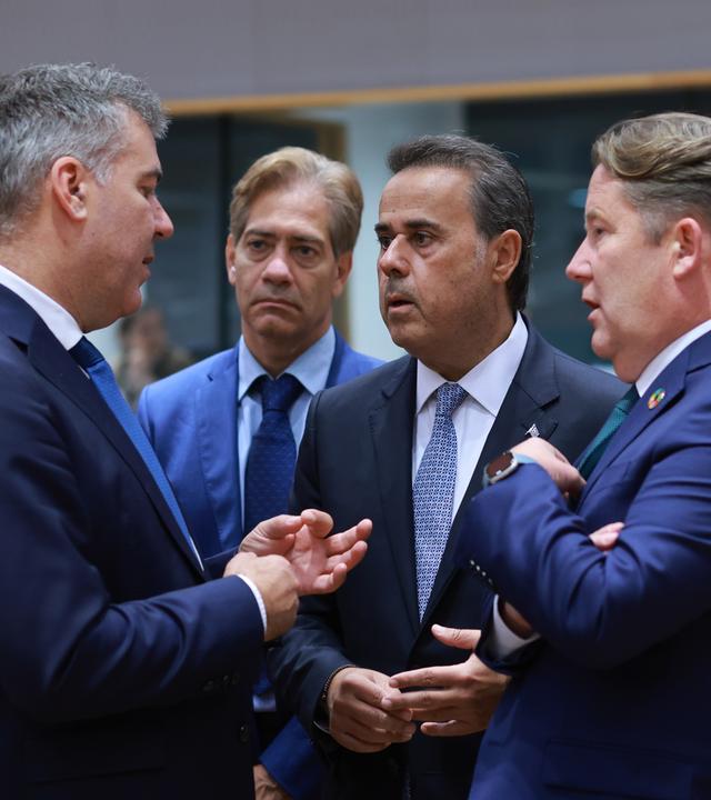 Vier Männer in Anzügen, die im Gespräch sind - darunter der dänische Minister für Klima und Energie, Lars Aagaard (links), und der griechische Minister für Energie und Umwelt, Stavros Papastavrou (zweiter von rechts),im Gespräch.