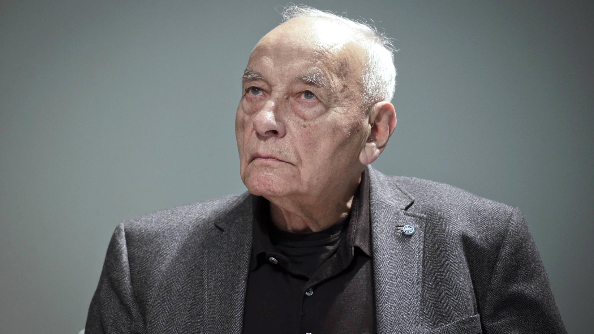 Das Porträtfoto des Dichters Eugen Gomringer zeigt einen älteren Herr im dunklen Anzug.