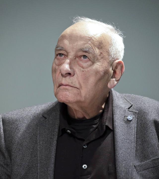 Das Porträtfoto des Dichters Eugen Gomringer zeigt einen älteren Herr im dunklen Anzug.