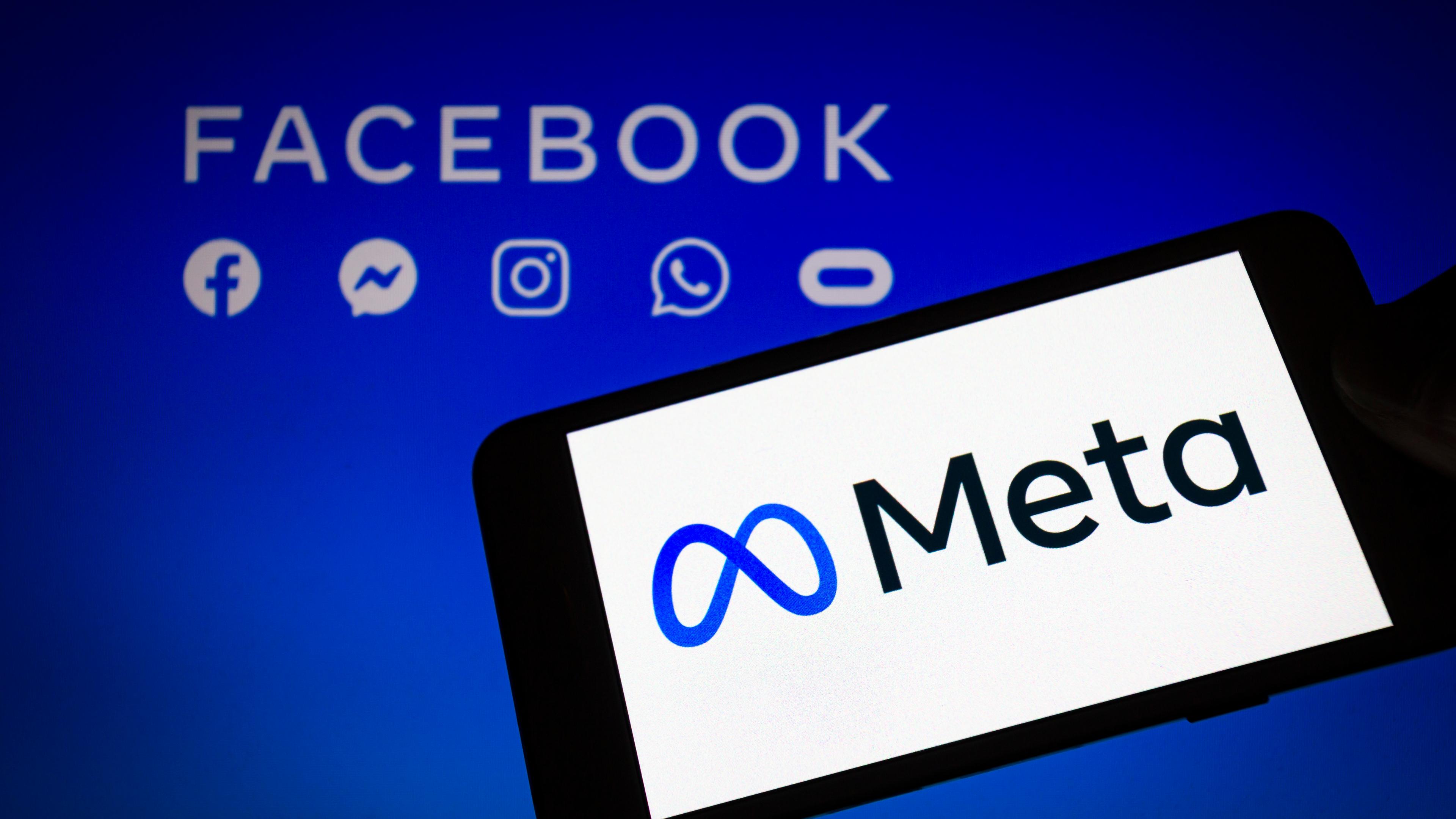 Das Logo von Meta, der neuen Dachmarke des Facebook-Konzerns, wird auf einem Smartphone angezeigt, im Hintergrund sind die Logos von Facebook, Messenger, Instagram, Whatsapp und Oculus zu sehen.