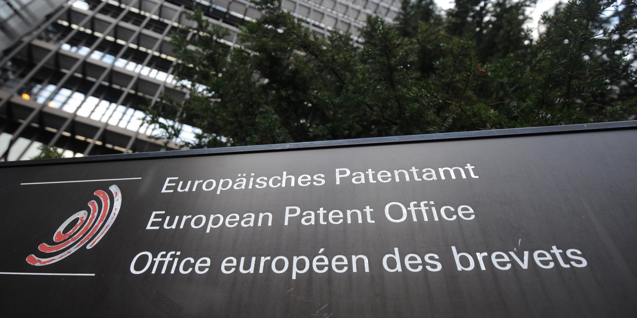 Schild mit der Aufschrift "Europäisches Patentamt in München" vor einem Gebäude der Institution.